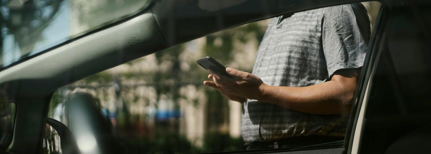 Man using smartphone near taxi car